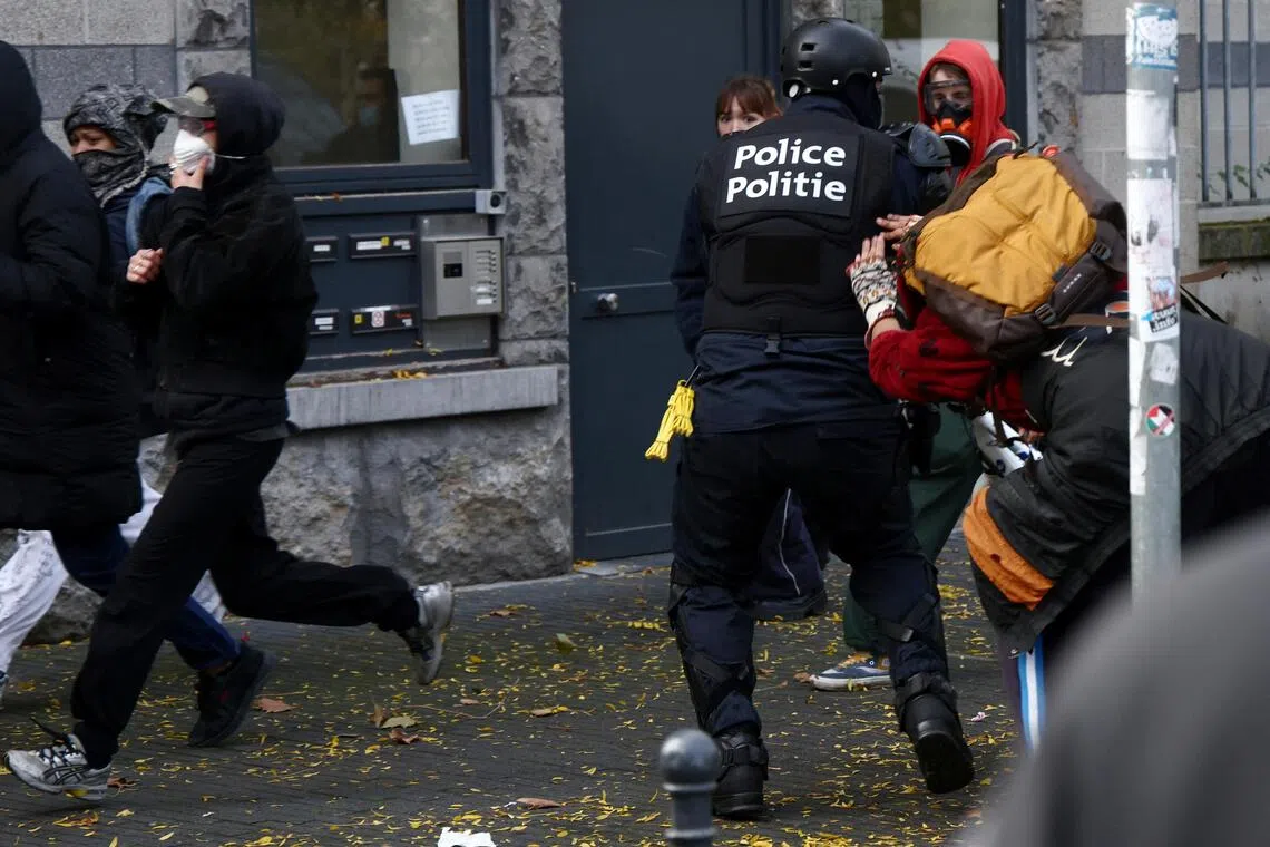A police officer scuffling with demonstrators in Brussels, Belgium, on Oct 24.
