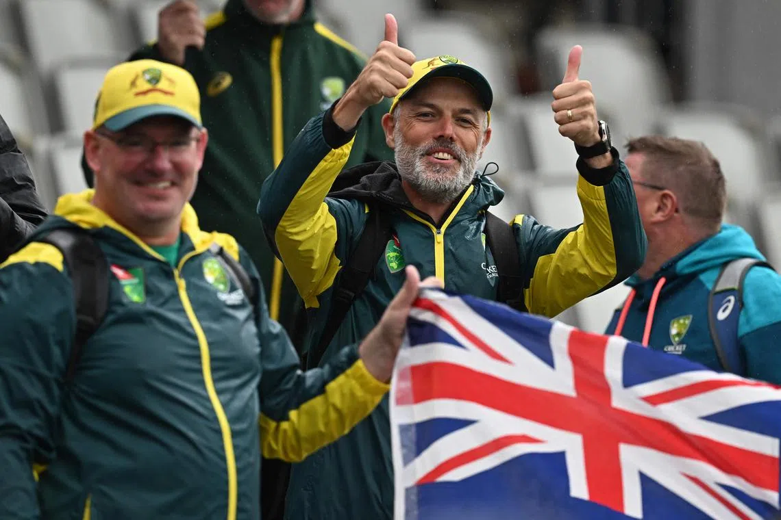 Australian fans celebrate after the game is abandoned without any play on day five of the fourth Ashes cricket Test match.