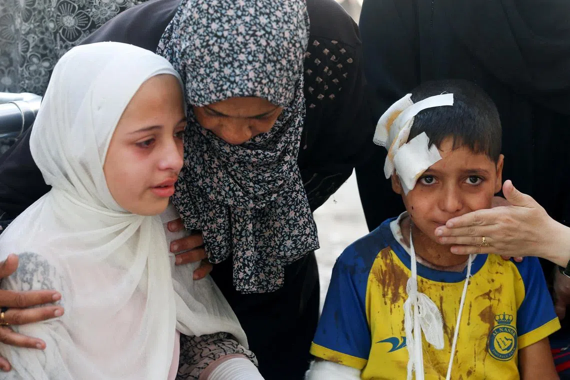 Mourners cry during the funeral of Palestinians who were killed by Israeli fire while trying to receive aid in central Gaza Strip.

