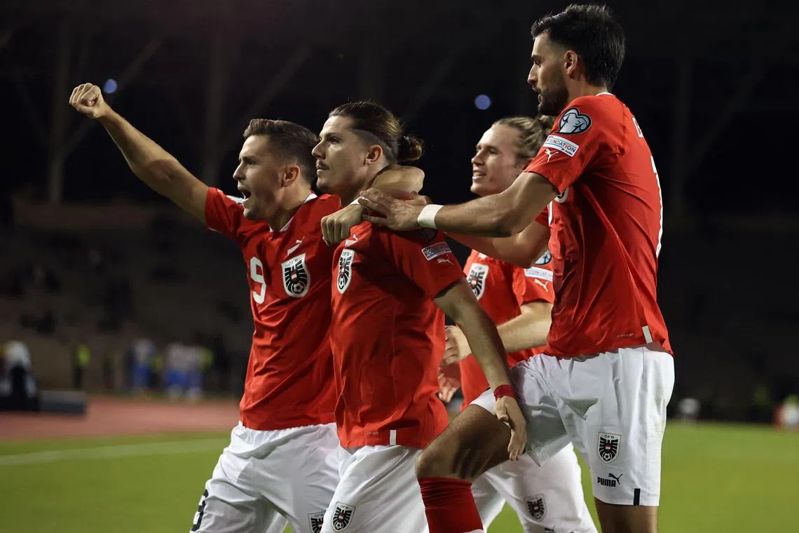Midfielder Marcel Sabitzer celebrates with teammates after scoring for Austria.