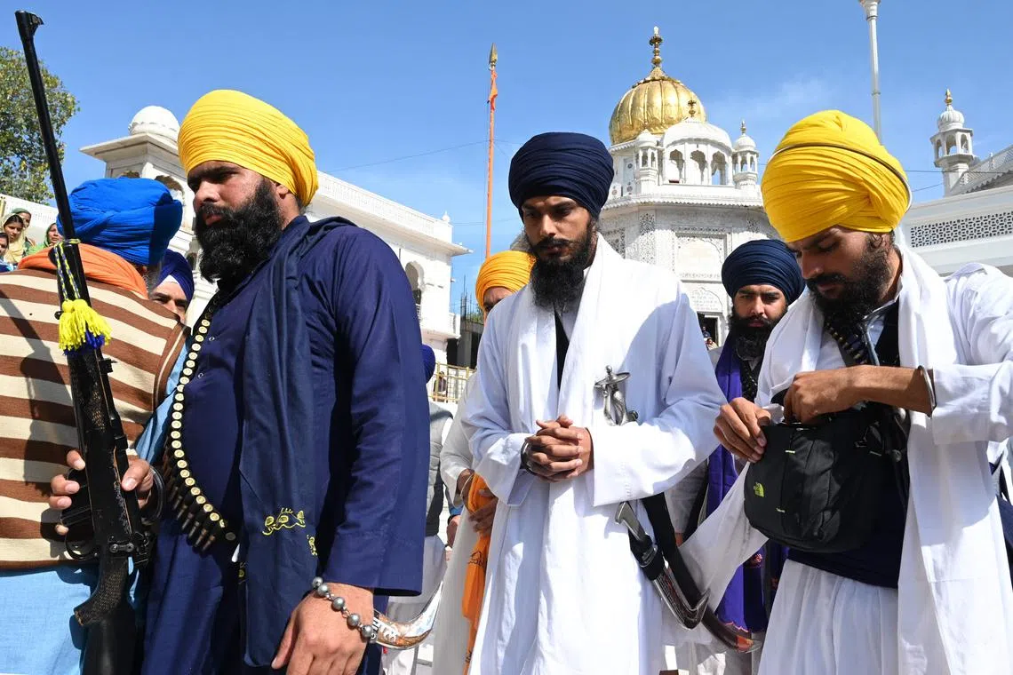'Waris Punjab De' chief Amritpal Singh (C) pays his respect at the Golden Temple in Amritsar on March 3, 2023. (Photo by Narinder NANU / AFP)