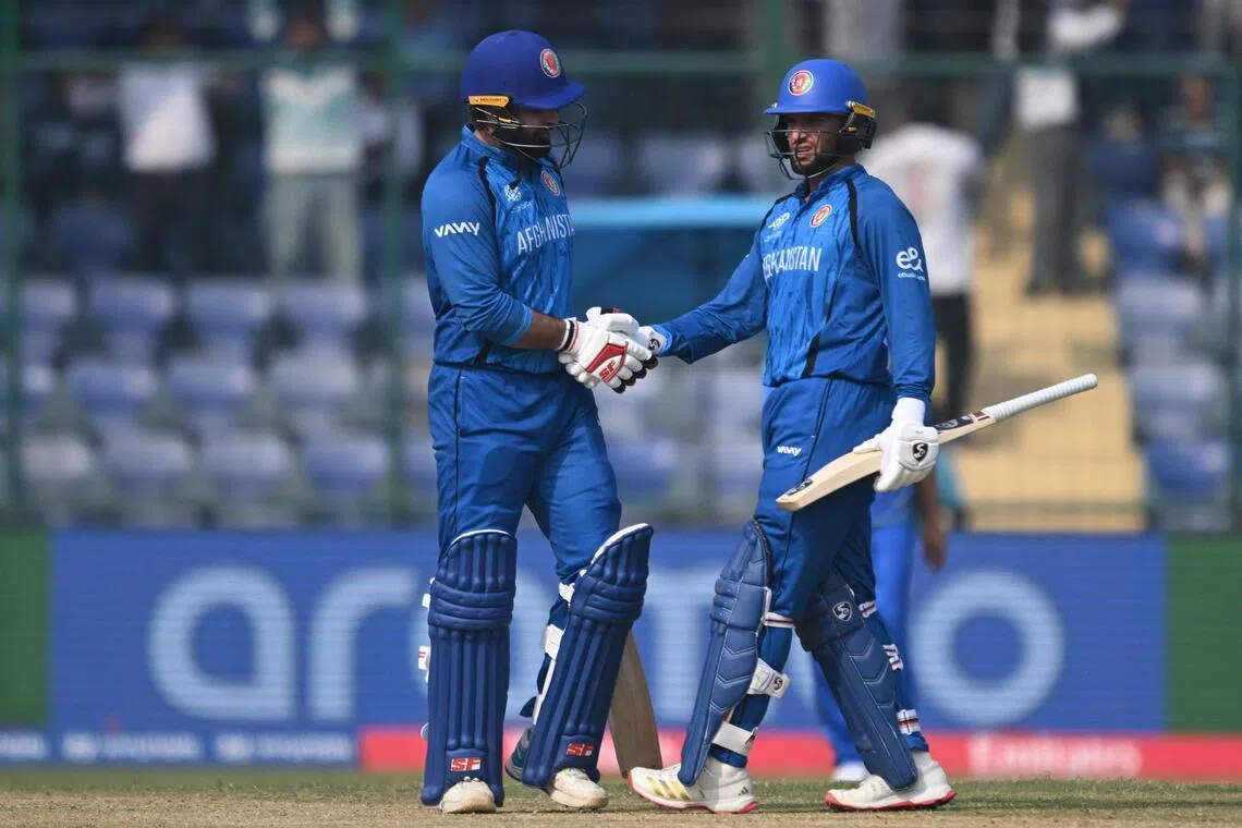 Afghanistan's Mohammad Ishaq (left) and Azmatullah Omarzai celebrate their team's win over United Arab Emirates in the ICC Men's T20 Cricket World Cup group-stage match at the Arun Jaitley Stadium in New Delhi on Feb 16, 2026.