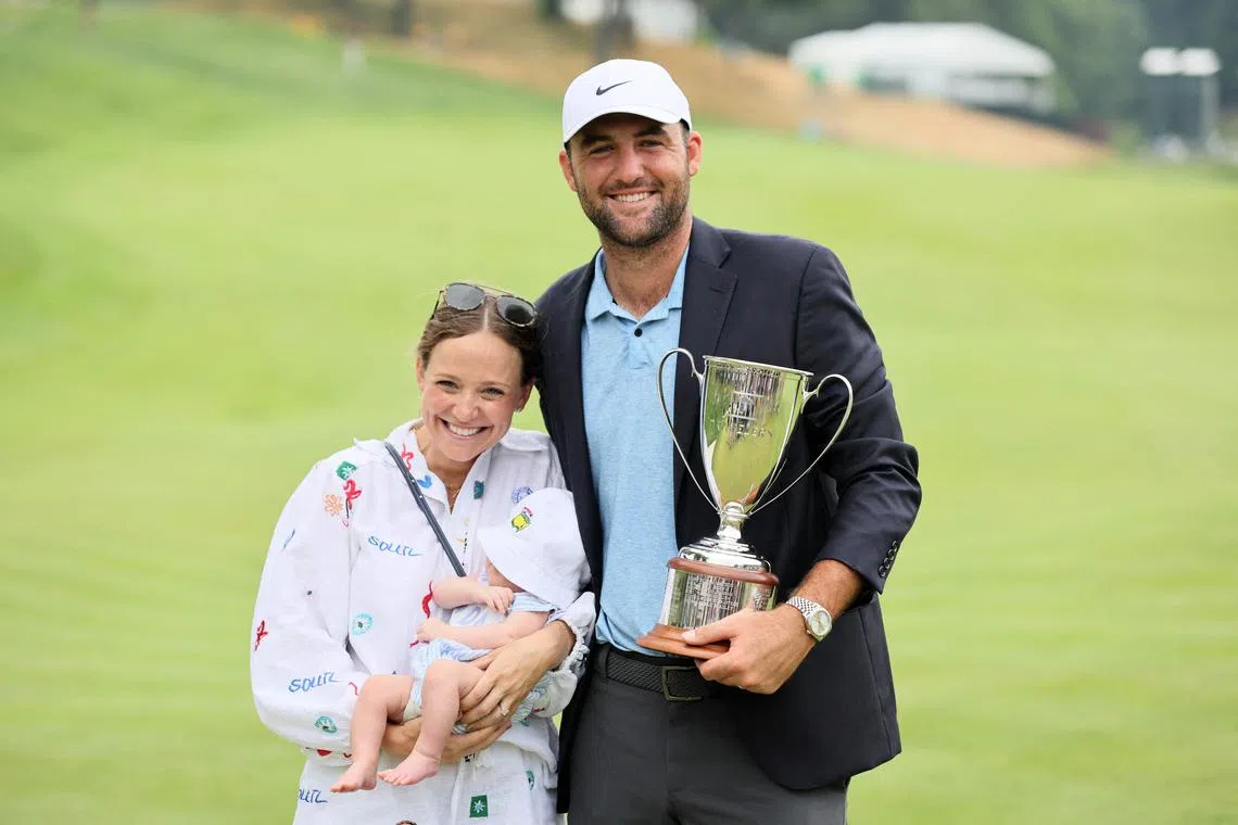 Scottie Scheffler poses with the trophy, his wife Meredith and their young son after winning the Travelers Championship at TPC River Highlands on June 23, 2024.