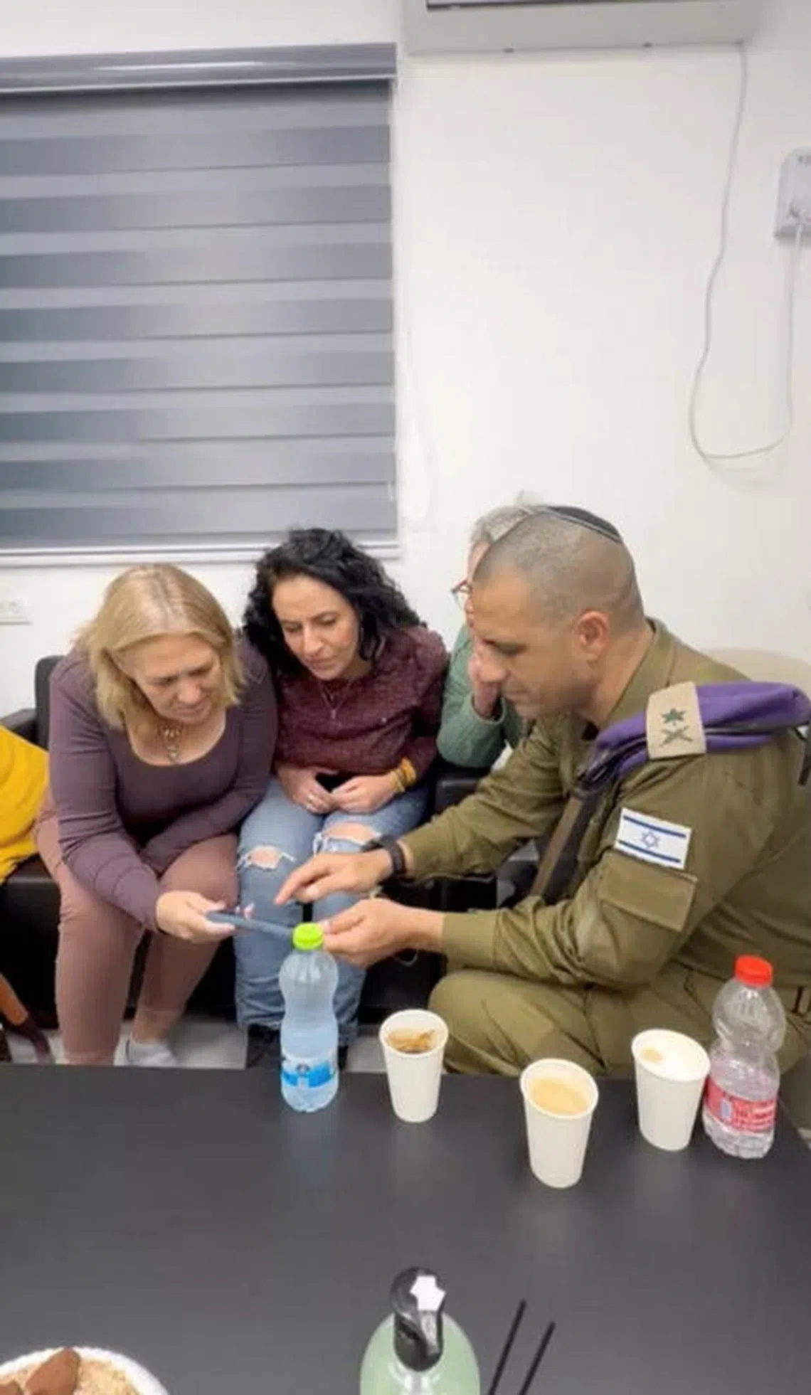 The mothers of hostages Romi Gonen, Doron Steinbrecher and Emily Damari, three female hostages who have been held in Gaza since the deadly October 7 2023 attack, watch footage of their release as part of a ceasefire deal in Gaza between Hamas and Israel, at a reception centre in Reim, southern Israel, in a screen grab from a handout video obtained by Reuters on January 19, 2025. Israel Defense Forces/Handout via REUTERS THIS IMAGE HAS BEEN SUPPLIED BY A THIRD PARTY. BEST QUALITY AVAILABLE