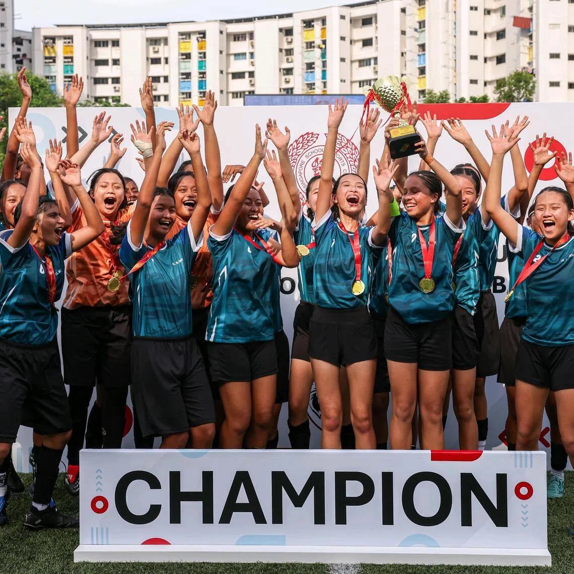 CBP W3 Combined team players celebrating with the champion's trophy after defeating Meridian Secondary School in the B Division Girls? League 1 football final at Jurong East Stadium on April 15, 2026. ST PHOTO: BRIAN TEO