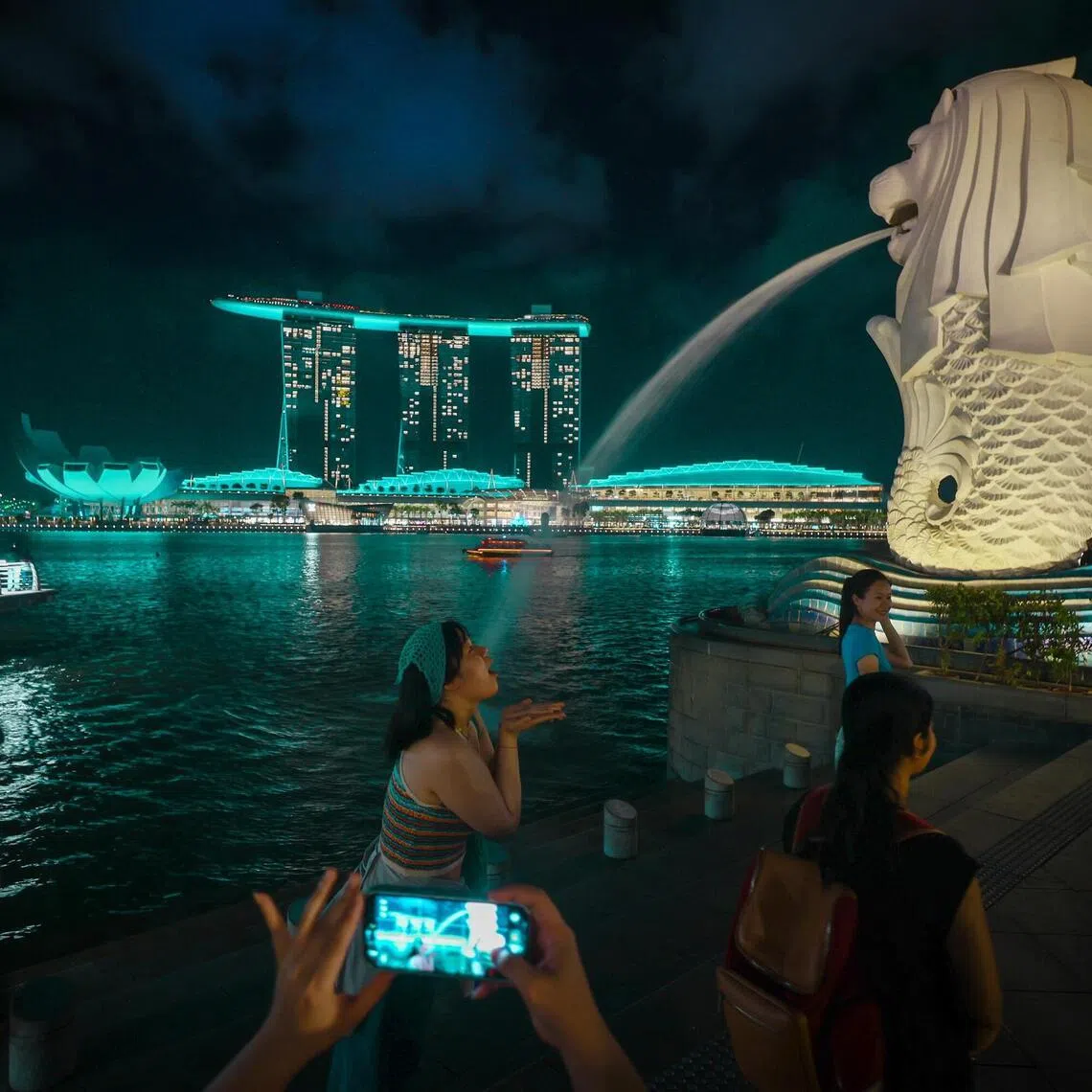 The Merlion and buildings in the Marina Bay area lit up in green and white as part of the DrugFreeSG light up on June 26.