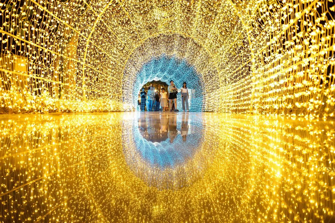Visitors walk through a tunnel made of light installations at the Nasatta Light festival, in Thailand’s Ratchaburi province on Jan 13, 2024. 