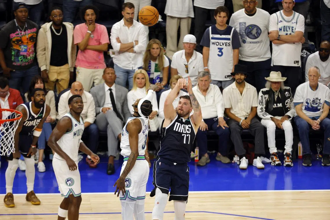 Dallas Mavericks guard Luka Doncic shooting over Minnesota Timberwolves forward Jaden McDaniels in the fourth quarter during his team's 108-105 Western Conference Finals Game 1 win at Target Centre on May 22.