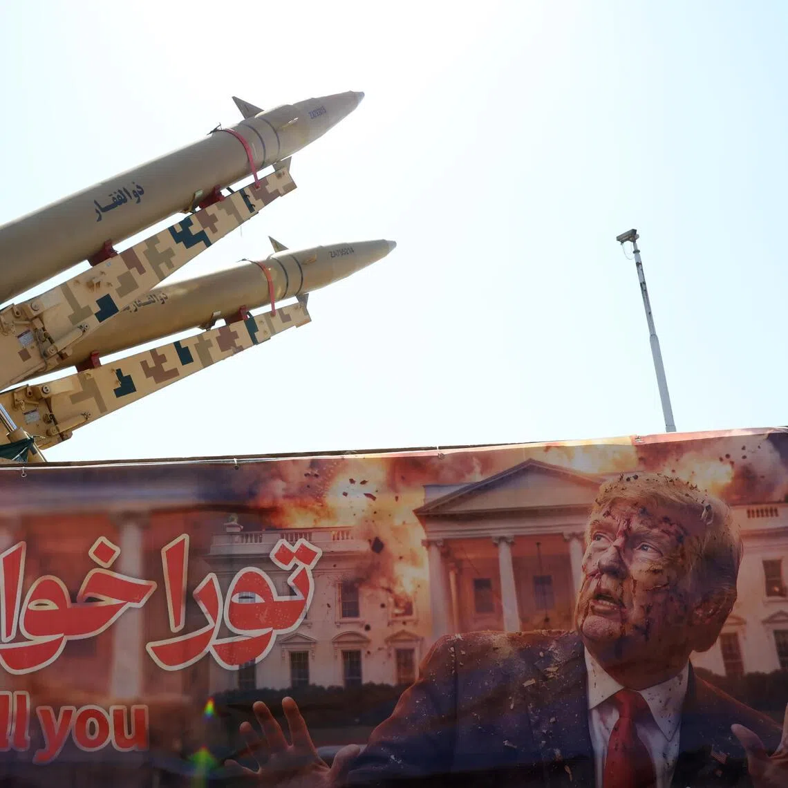 Iranian missiles are on display above a banner depicting US President Trump at Azadi Square in Tehran.