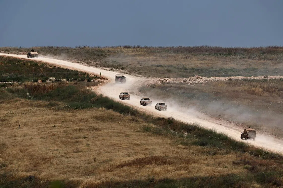 Military vehicles move within southern Lebanon, as seen from the Israeli side of the border in the Upper Galilee, northern Israel, on June 17.