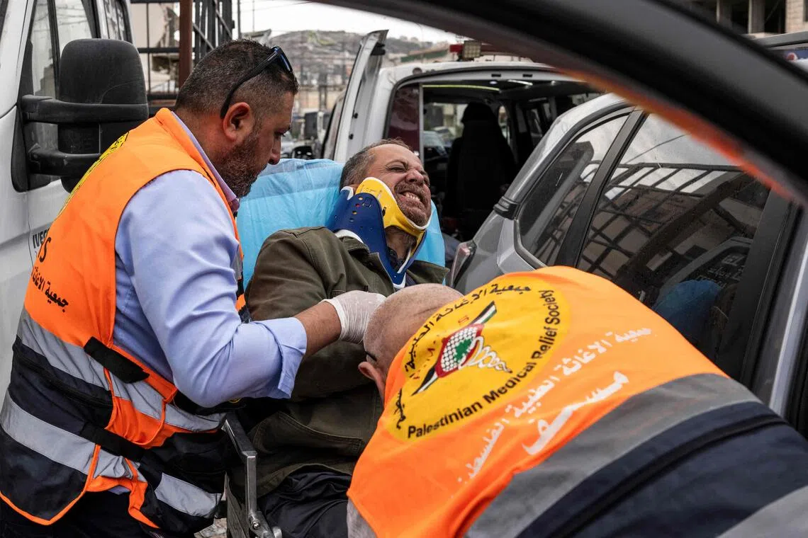 Palestinian first responders taking AFP photographer Jaafar Ashtiyeh to seek medical help on Oct 6, after he was beaten by several Israelis in Aqraba, in the Israeli-occupied West Bank.
