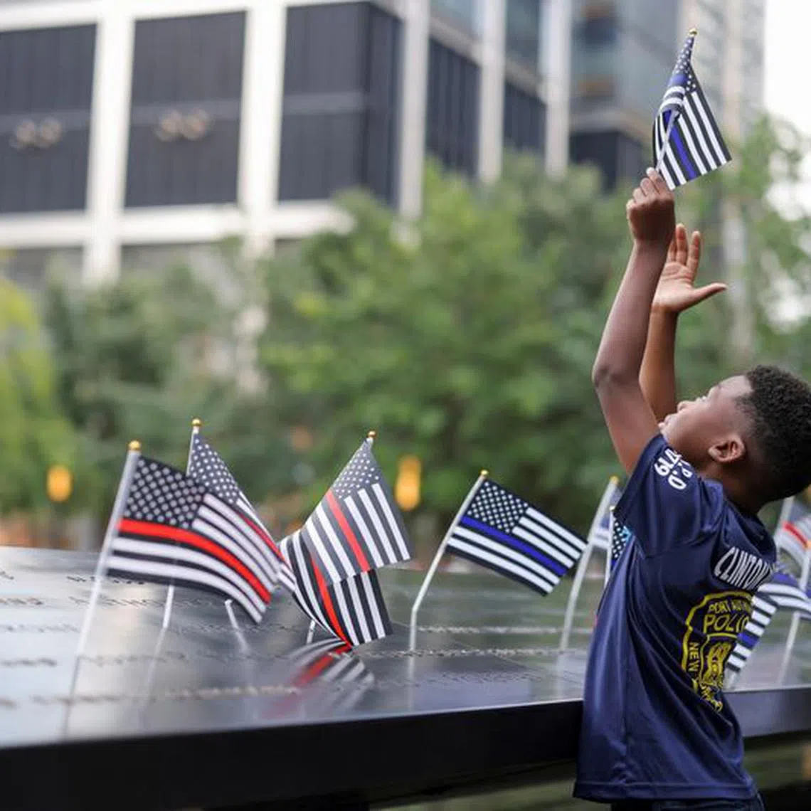 A person holds a flag, on the day of the 22nd anniversary of the September 11, 2001 attacks on the World Trade Center at the National September 11 Memorial & Museum, in New York City, U.S., September 11, 2023. REUTERS/Andrew Kelly