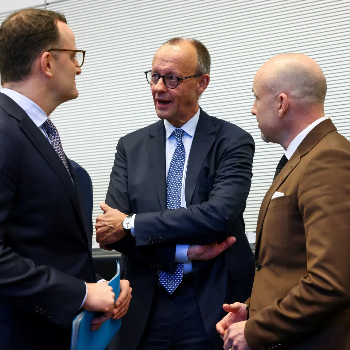 German Chancellor Friedrich Merz speaks to Christian Democratic Union's Jens Spahn, the CDU/CSU parliamentary group leader, and member of the German Bundestag Alexander Hoffmann on the day of a CDU/CSU fraction meeting in Berlin, Germany, December 2, 2025.   REUTERS/Christian Mang