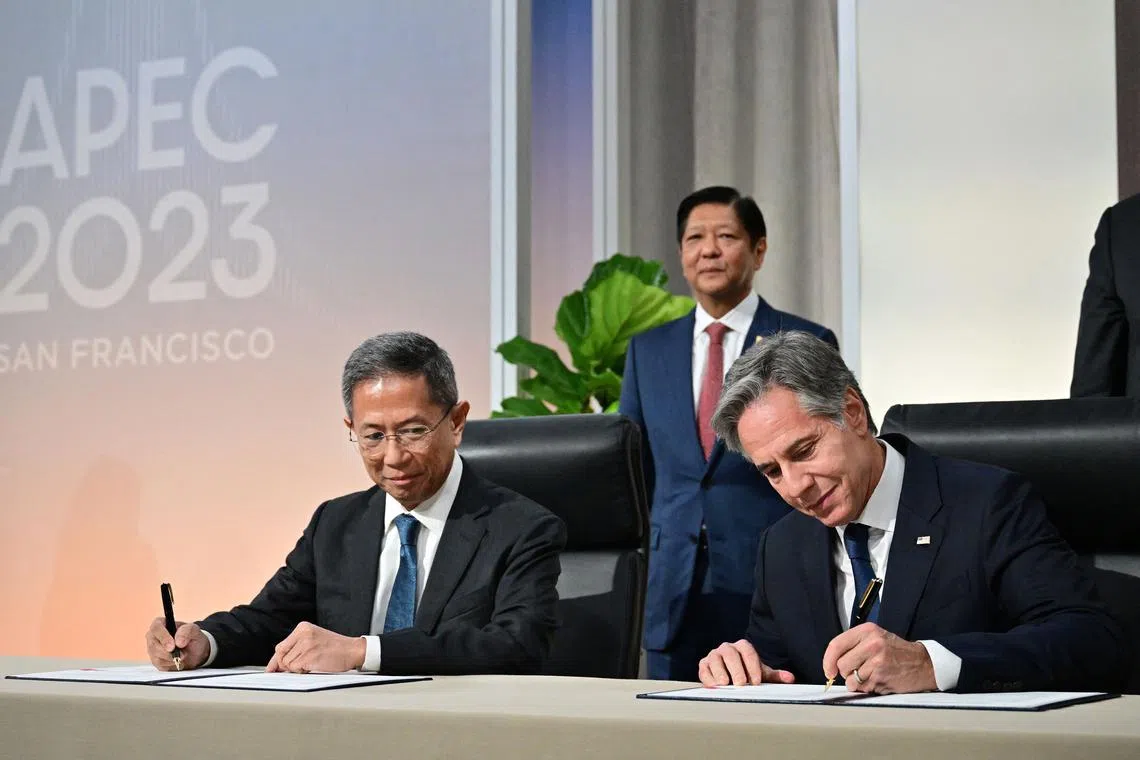 US Secretary of State Antony Blinken (left) and Philippines' Secretary of Energy Raphael Lotilla sign the agreement, with Philippines' President Ferdinand Marcos Jr looking on.