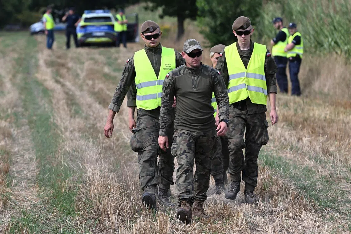 Members of Polish military and police secure a cornfield where an unidentified object fell in Osiny, eastern Poland, on Aug 20.