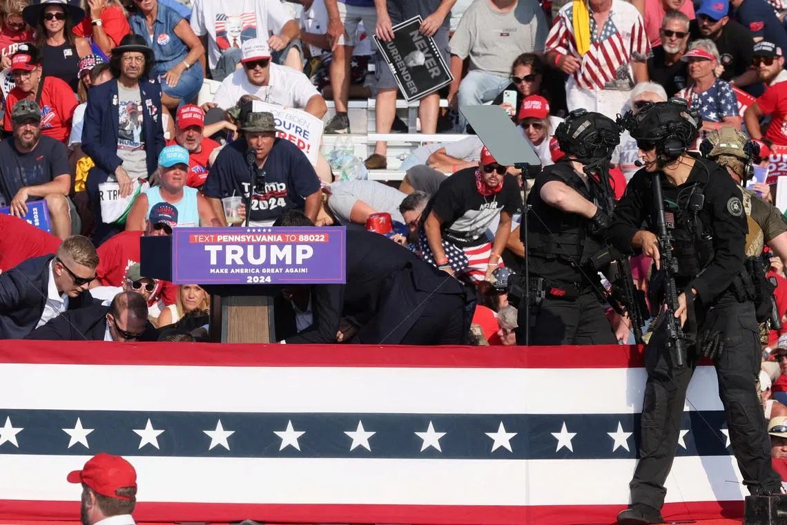 Republican presidential candidate and former U.S. President Donald Trump is assisted by U.S. Secret Service personnel after gunfire rang out during a campaign rally at the Butler Farm Show in Butler, Pennsylvania, U.S., July 13, 2024. REUTERS/Brendan McDermid