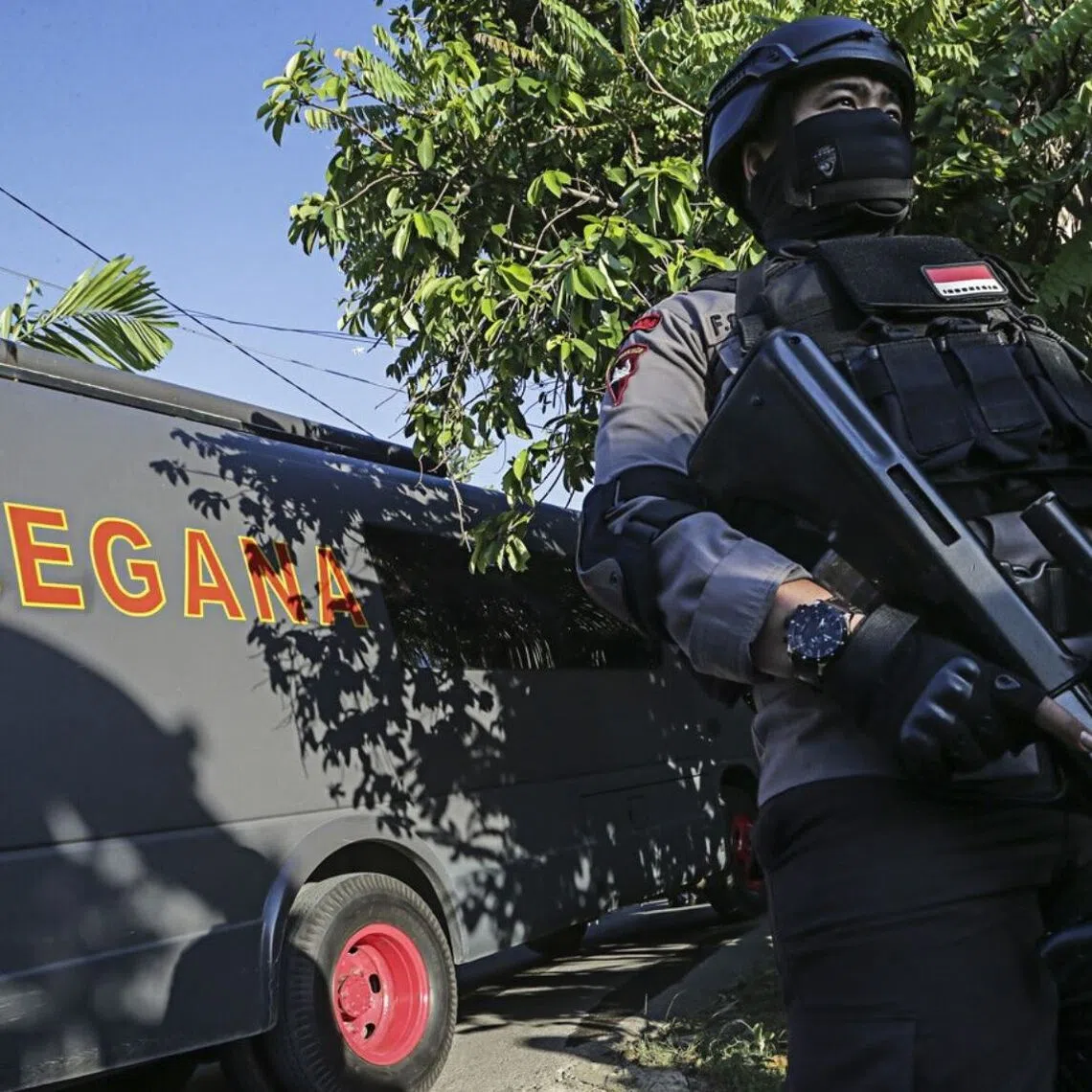 A fully armed police on guard in 2016 in an area leading to the house of a suspected terrorist in Batam, Riau Islands.
