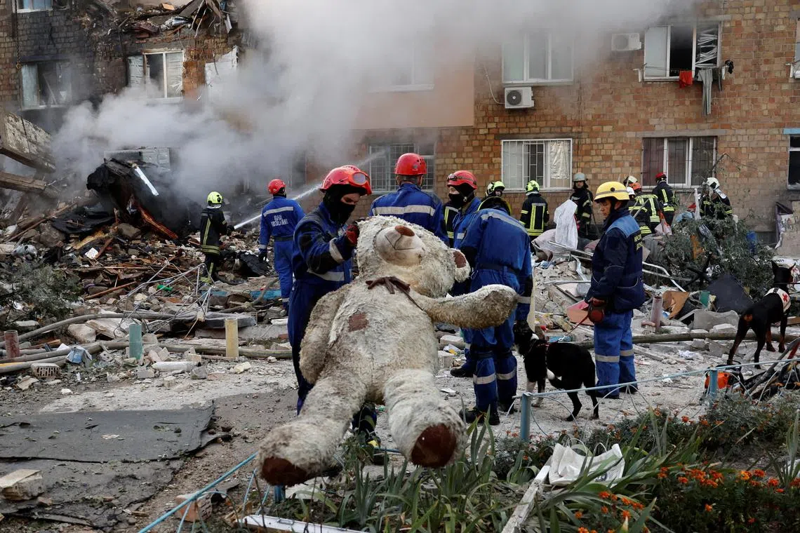 A rescuer holds a soft toy at the site of an apartment building which was hit by Russian missile and drone strikes, amid Russia's attack on Ukraine, in Kyiv, Ukraine August 28, 2025. REUTERS/Thomas Peter REFILE - QUALITY REPEAT     TPX IMAGES OF THE DAY     