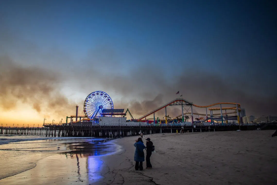 California's Santa Monica Pier on Jan 11 as smoke from the Palisades fire cast a pall over the beach area. 