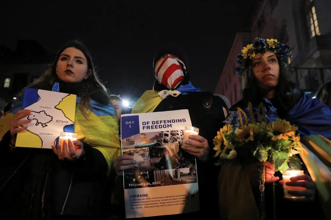 People attend a candlelight vigil in front of the Russian embassy in New York to mark the one year anniversary of Russia's invasion of Ukraine.