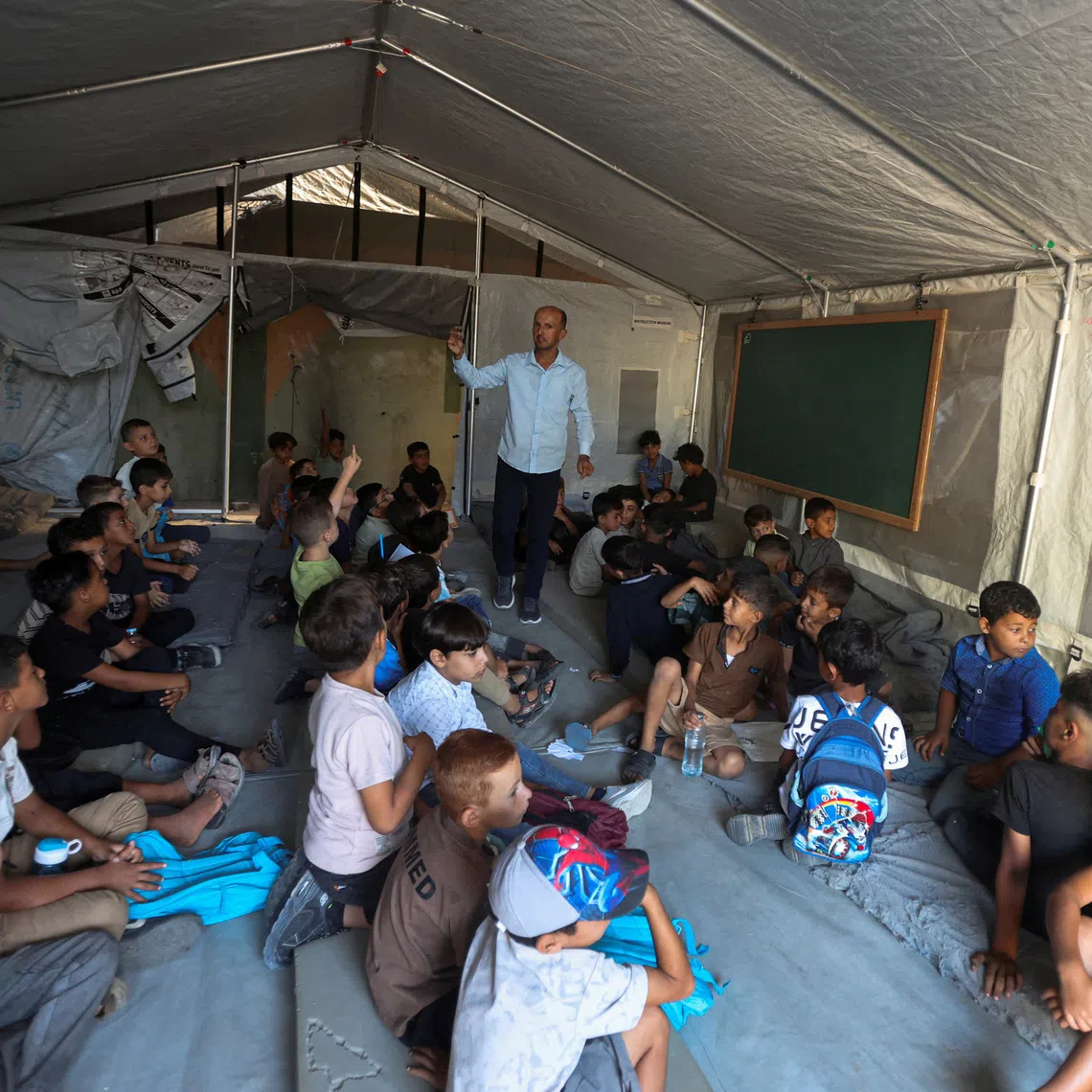 Palestinian students attending their first day of the new school year inside a tent classroom at a school in Khan Younis, in the southern Gaza Strip, on Sept 19.