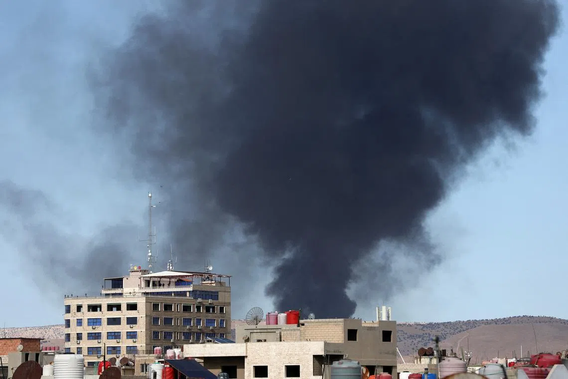 FILE PHOTO: Smoke rises from Syria's Kurdish-controlled northeast city of Qamishli, Syria October 5, 2023. REUTERS/Orhan Qereman/File Photo