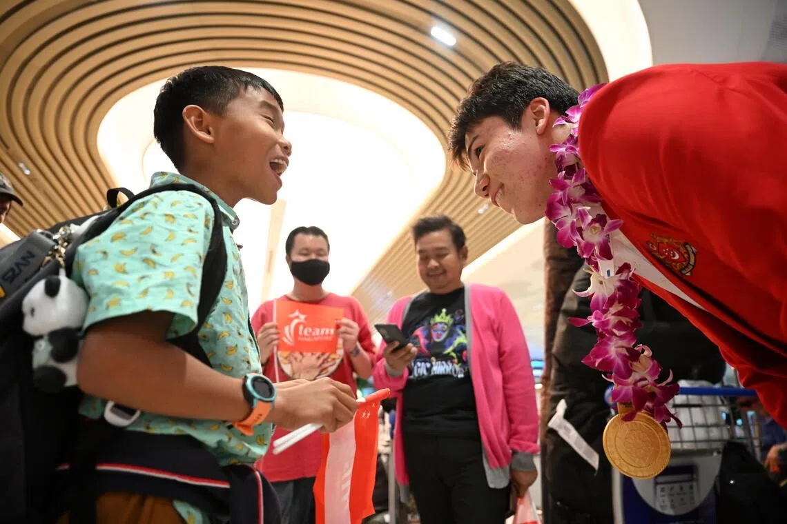 Max Maeder (right) chats with a young supporter, Ange Chew, 11 as the Singapore Sailing contingent arrives at Changi Airport Terminal 2, following following the conclusion of their 2025 SEA Games campaign on Dec 19, 2025.