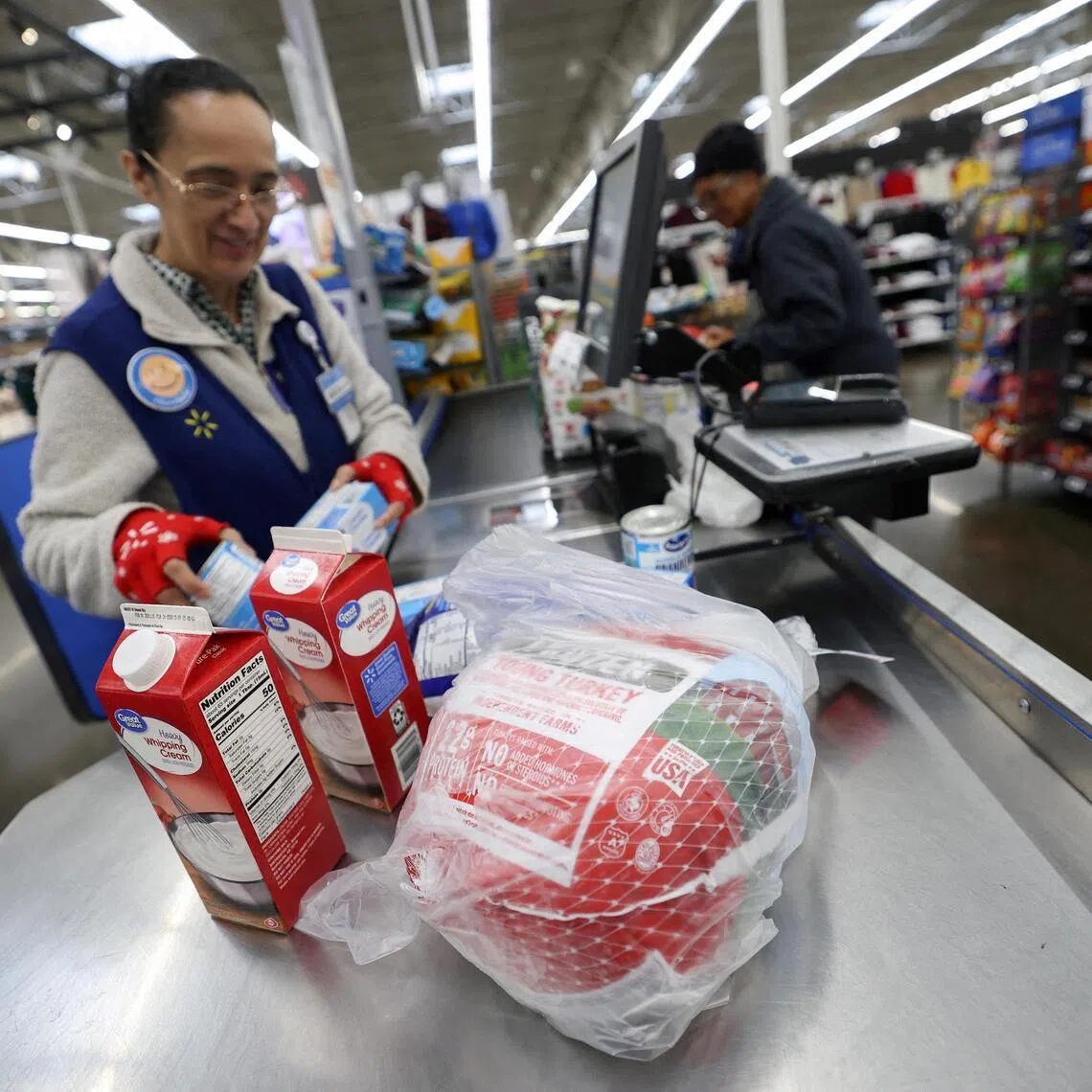 FILE PHOTO: A cashier loads a turkey and other groceries for checkout at a Walmart Supercenter retail store in North Bergen, New Jersey, U.S., November 21, 2025.  REUTERS/Mike Segar/File Photo
