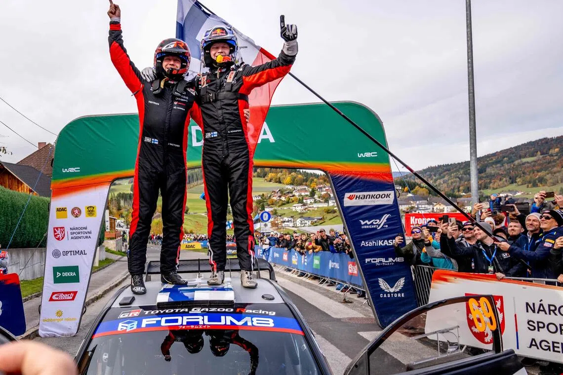 Finnish driver Kalle Rovanpera (right) and co-driver Jonne Halttunen stand on top of their Toyota GR Yaris Rally1 car as they celebrate their victory on the final day of the World Rally Championship Central European Rally at the end of the SS18 Muehltal stage in the village of Peilstein near Rohrbach, Upper Austria on Oct 19, 2025.