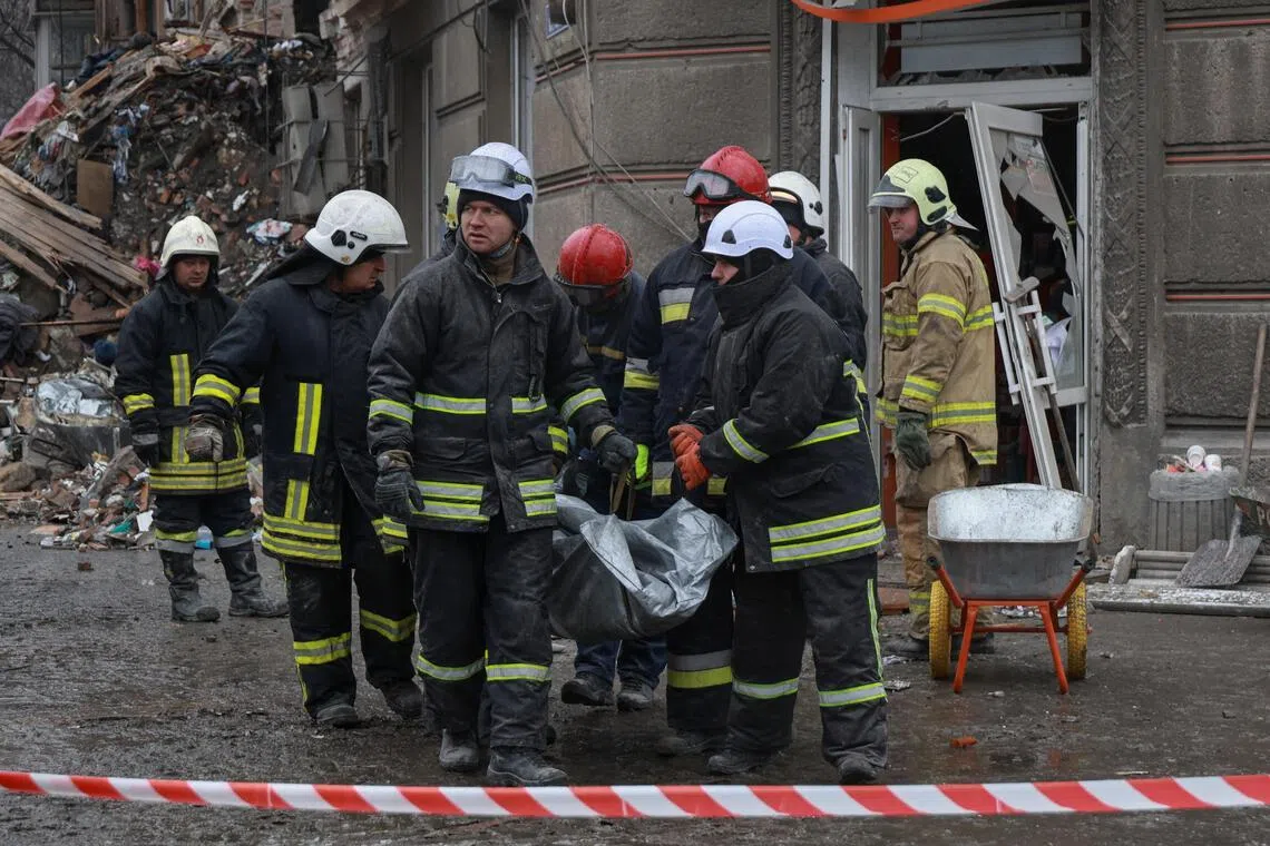 Ukrainian rescuers carrying the body of a person who was found under the debris of a residential building in Odesa on Jan 27, following overnight Russian strikes on the city.