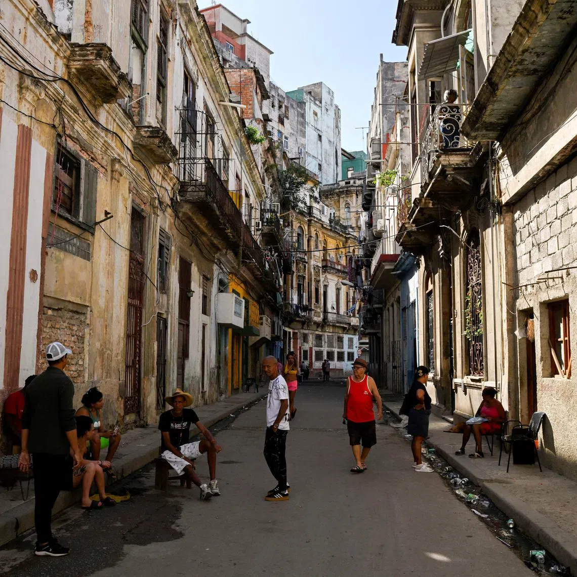People spend time on a street sidewalk on Jan 11, as US-Cuba tensions rise after US President Donald Trump vowed to stop Venezuelan oil from reaching Cuba.
