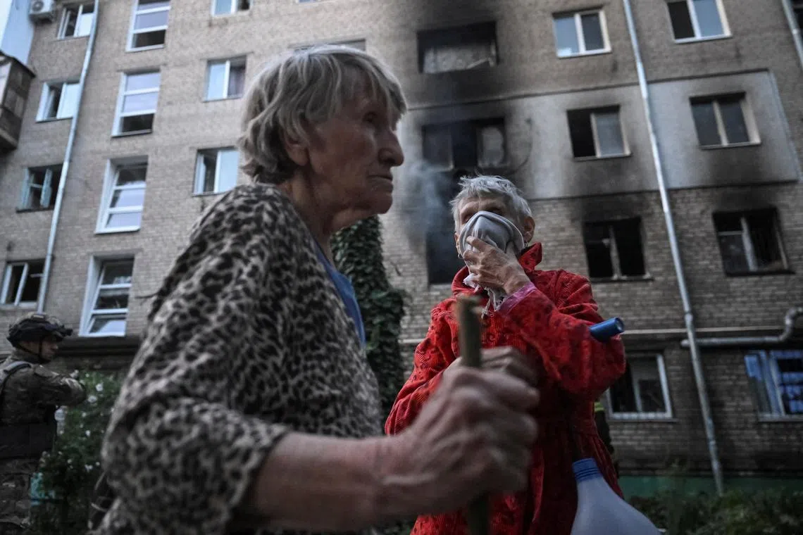 Residents stand near their apartment building, hit during a Russian drone and missile strike, amid Russia's attack on Ukraine, in Zaporizhzhia, Ukraine August 30, 2025. REUTERS/Stringer