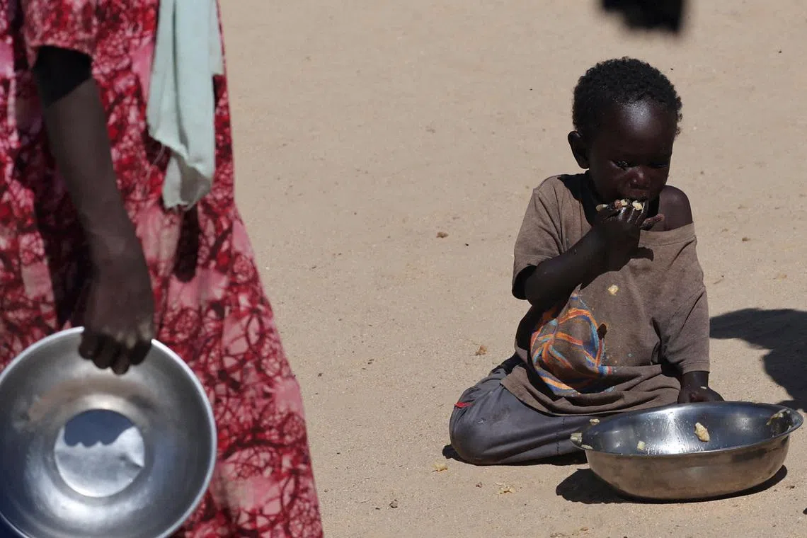 FILE PHOTO: A Sudanese orphaned child refugee from al-Fashir eats a free meal provided by the ?Group Kitchen Project? inside the Tine transit camp in eastern Chad, amid the conflict between the paramilitary Rapid Support Forces (RSF) and the Sudanese army, November 22, 2025. REUTERS/Amr Abdallah Dalsh/File Photo