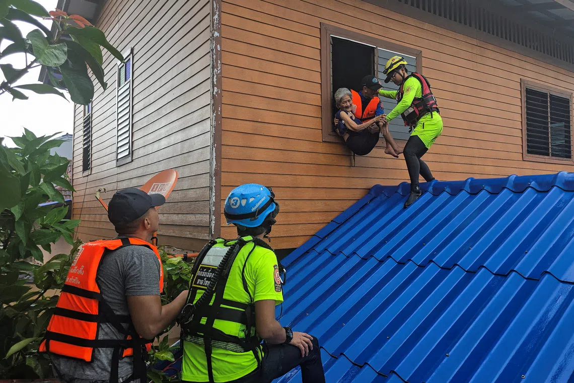 Members of a volunteer team evacuate a resident from her home, which is partially submerged in a flooded area in Hat Yai district, affected by heavy rainfall, which has impacted several provinces in southern Thailand and has killed several people, in Songkhla province, Thailand, November 25, 2025. REUTERS/Sithichai Chootochana