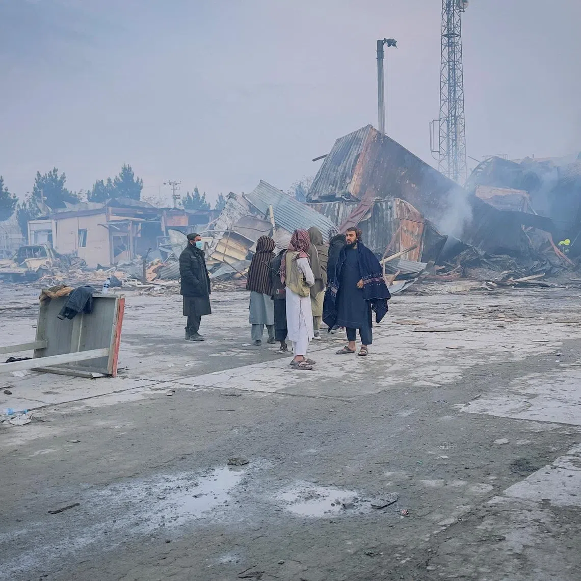People stand next to a drug users rehabilitation hospital destroyed in what the Taliban said was a Pakistani air strike, in Kabul, Afghanistan, March 17, 2026. REUTERS/Sayed Hassib