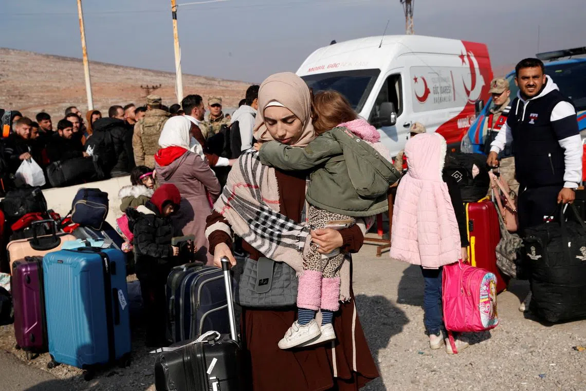 Syrian migrants wait at the Cilvegozu border gate to cross into Syria, after Syrian rebels announced that they have ousted Syria's Bashar al-Assad, in the Turkish town of Reyhanli in Hatay province, Turkey, December 10, 2024. REUTERS/Dilara Senkaya