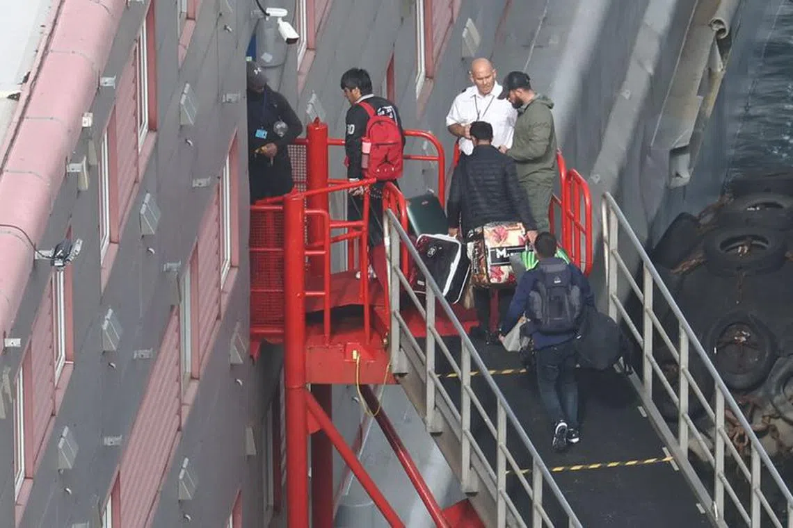 People, believed to be asylum seekers, arrive to be housed on the Bibby Stockholm accommodation barge at Portland Port, Portland near Weymouth in Britain, October 19, 2023. REUTERS/Toby Melville
