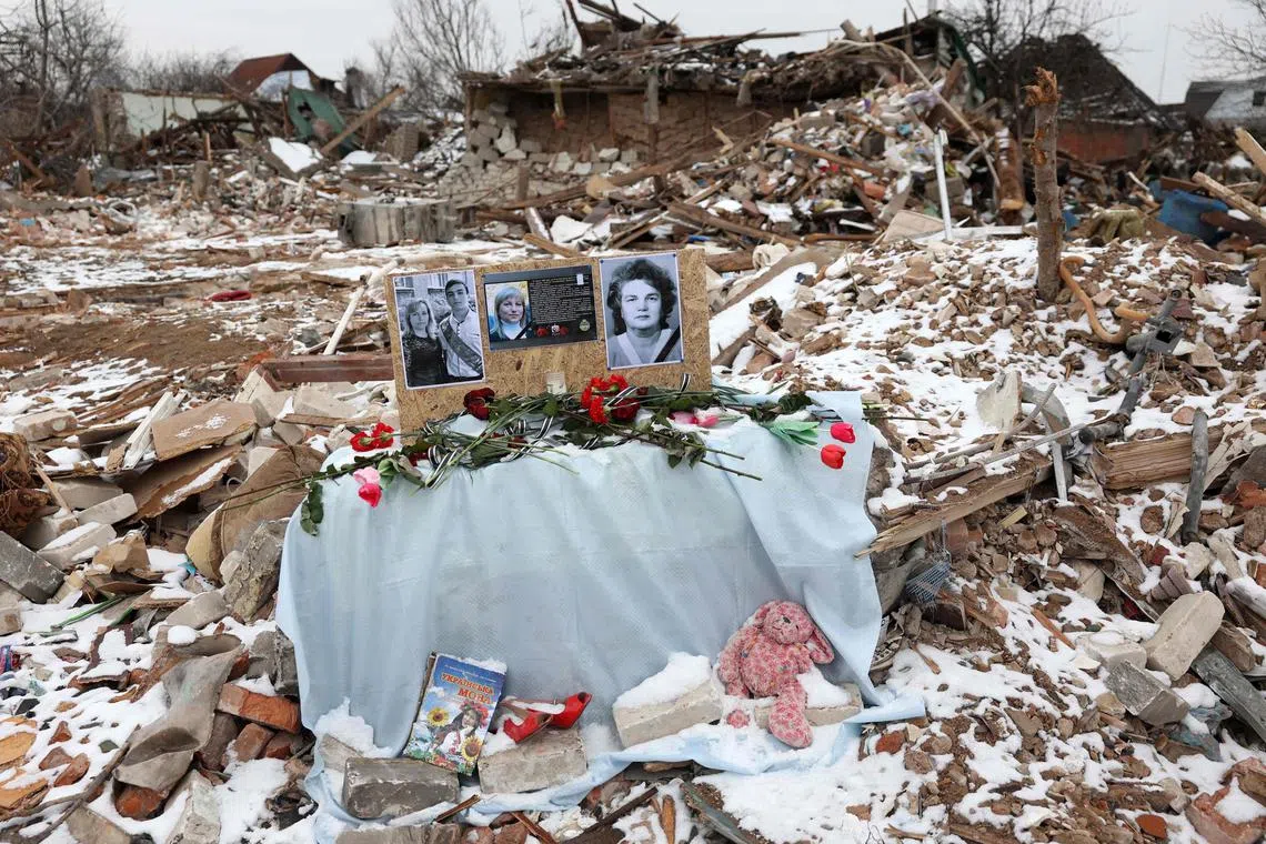 TOPSHOT - This photograph taken on February 22, 2024 shows the portraits of Valentyna Leonicheva, 74, Lyudmyla Kravchenko, 46, Sergiy Kravchenko, 23, displayed during a funeral ceremony at the site of their home, destroyed by a Russian missile strike, in Kramatorsk, Donetsk region, on February 22, 2024, amid the Russian invasion of Ukraine. (Photo by Anatolii STEPANOV / AFP)