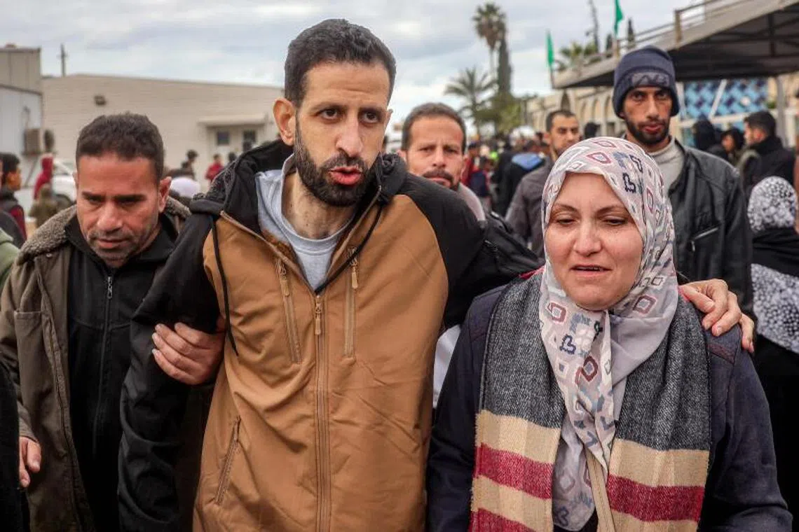 One of the Palestinian prisoners released in the fifth hostage-prisoner swap under the Gaza ceasefire deal walks with his mother upon arrival at the European Hospital in Khan Yunis in the southern Gaza Strip on February 8, 2025. Hamas militants handed over three Israeli hostages on February 8, as part of the fifth exchange under a fragile Gaza ceasefire, with 183 prisoners held by Israel due to be released later in the day. (Photo by Eyad BABA / AFP)