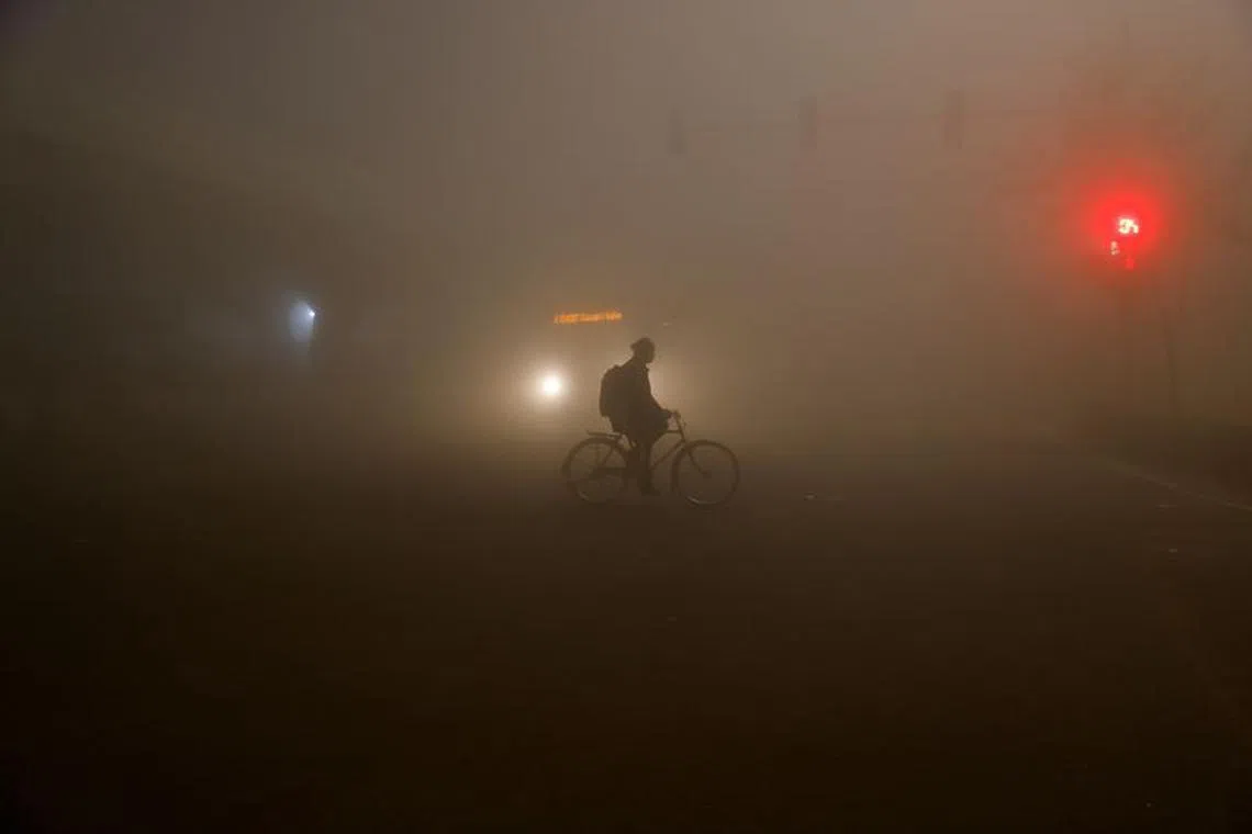FILE PHOTO: A man rides a bicycle amidst heavy fog in New Delhi, India, December 27, 2023. REUTERS/Anushree Fadnavis/File Photo