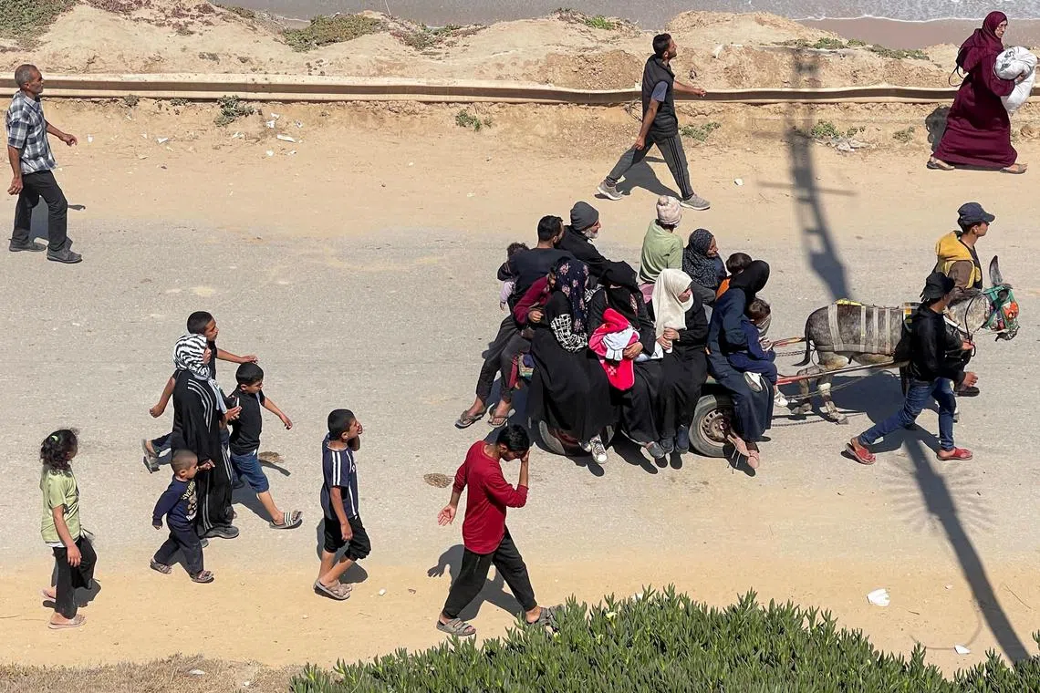 Palestinians, who were displaced by Israel's military offensive on south Gaza, make their way as they attempt to return to their homes in north Gaza, amid the ongoing conflict between Israel and Hamas, as seen from central Gaza Strip April 14, 2024. REUTERS/Ramadan Abed