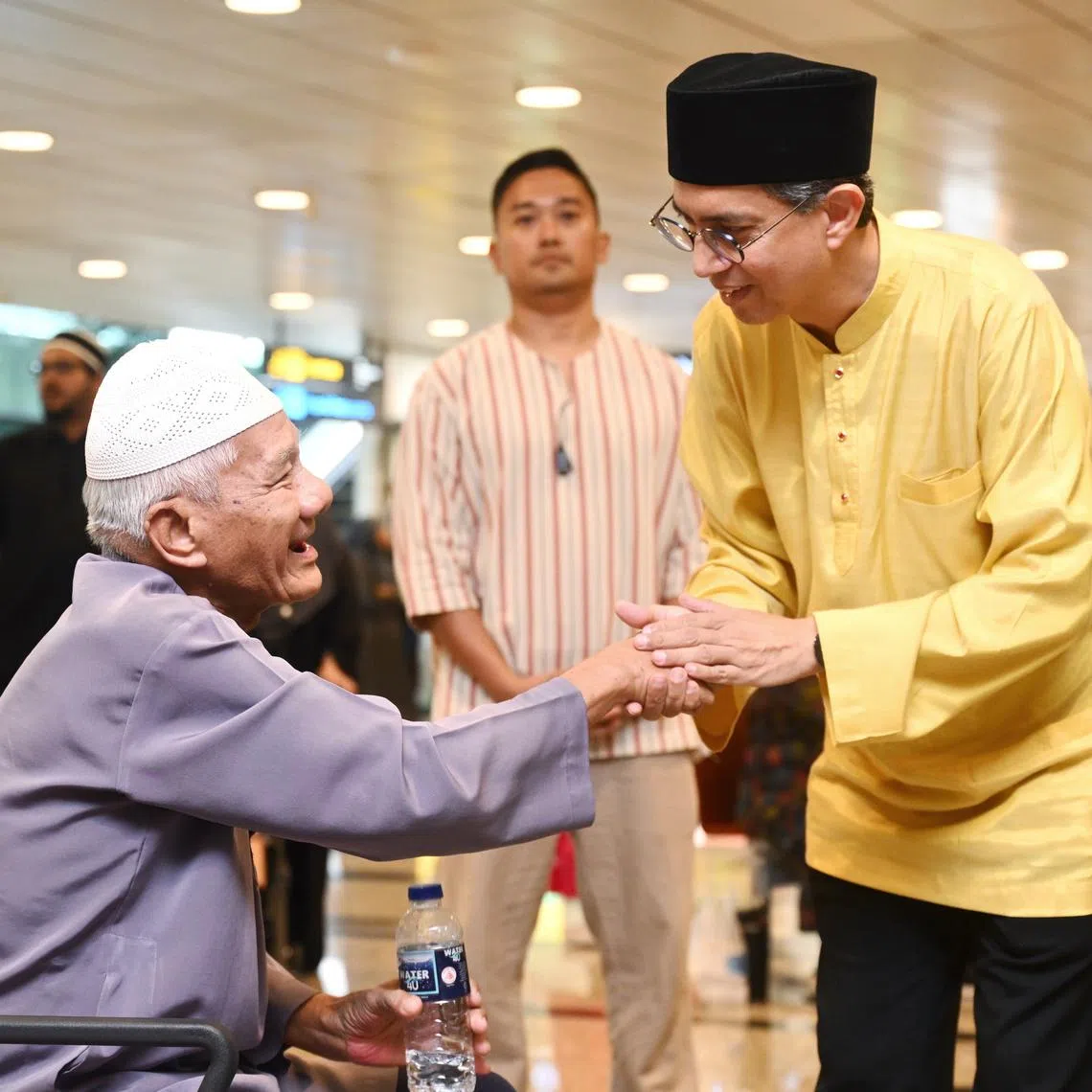 Acting Minister-in-charge of Muslim Affairs Dr Faishal Ibrahim greeting relatives of a member of the first group of Singapore Haj pilgrims at Changi Airport Terminal 3 on June 13.