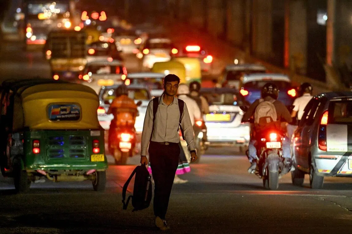 An office-goer walks along a road near the Manyata Tech Park in Bengaluru on September 22, 2025. PHOTO: AFP
