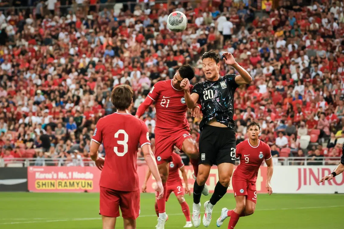 Singapore's Muhammad Safuwan Baharudin (21, red) and South Korea's Kwon Kyungwon (20, black) fighting for the ball at the FIFA World Cup 2026 qualifier match held at the National Stadium on June 6, 2024.