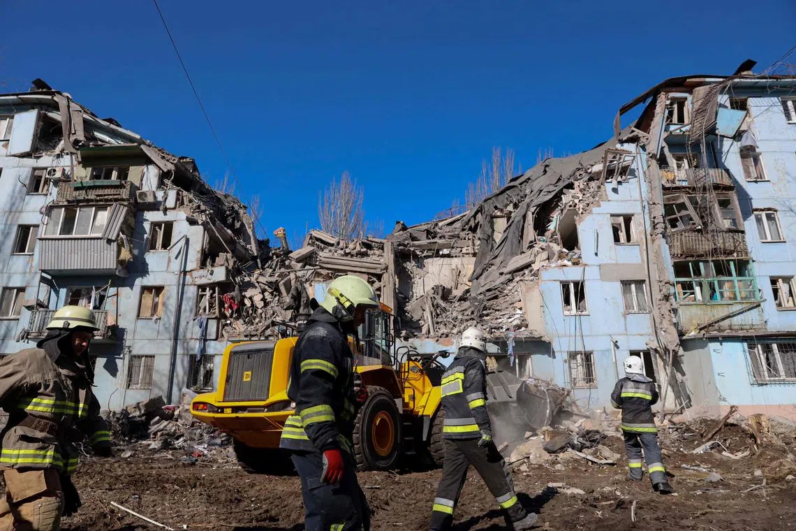 Ukrainian rescuers work on a residential building destroyed after a missile strike in Zaporizhzhia on March 2, 2023.