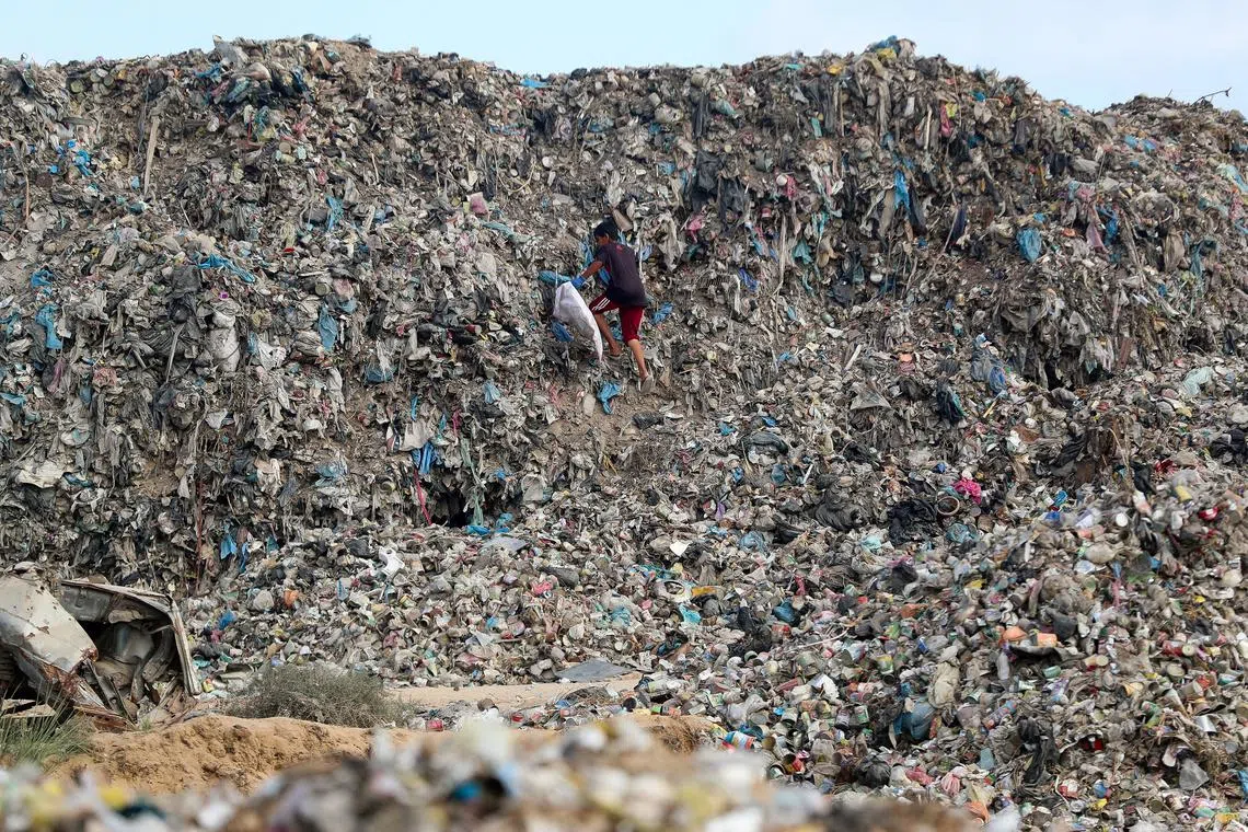 A Palestinian child searching for useable items at a dump site, amid an Israeli military operation, in the central Gaza Strip Sept 10, 2025. 