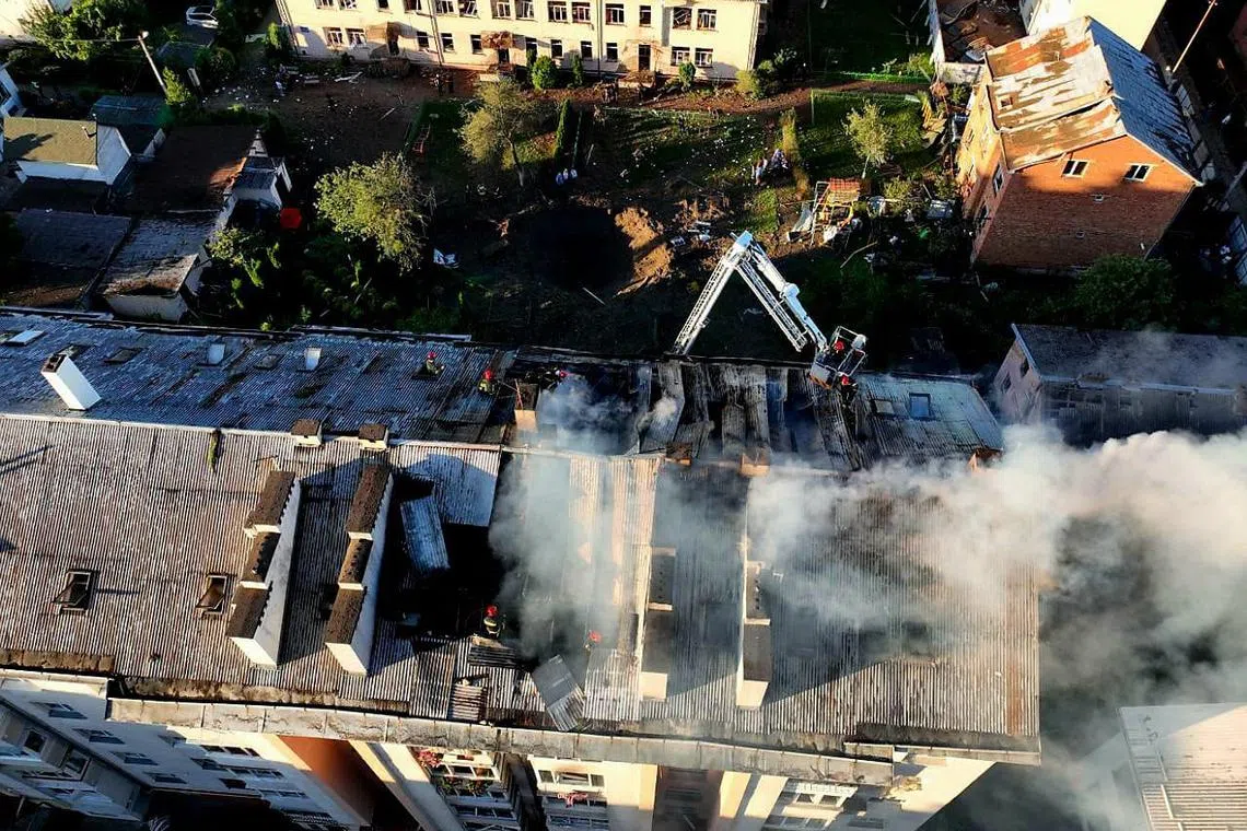 Rescuers fight a fire after missiles hit Lviv city, which till this week had been spared much of Russia's air attacks.