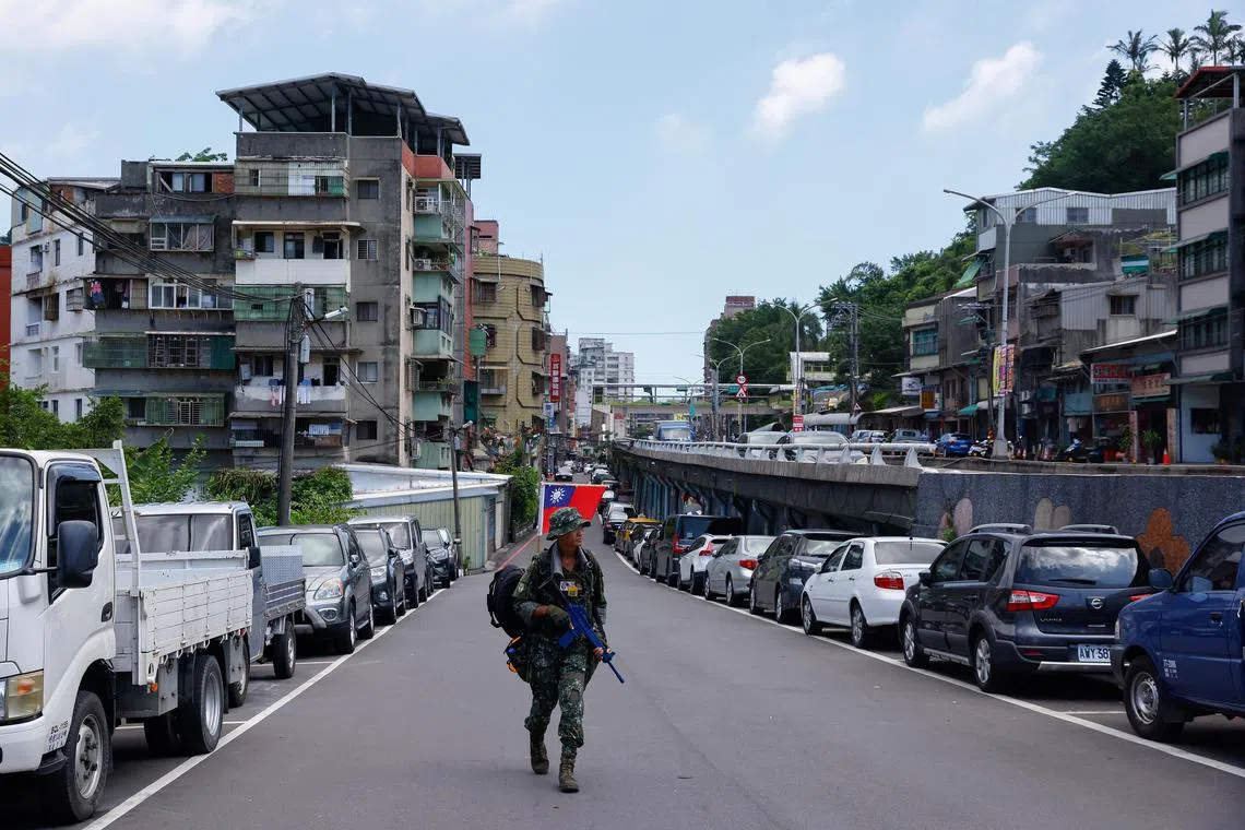 Tsai Tsung-lin, who is dressed in full camouflage and holds a plastic rifle, walks on a road, in Keelung, Taiwan August 21, 2023. REUTERS/Ann Wang