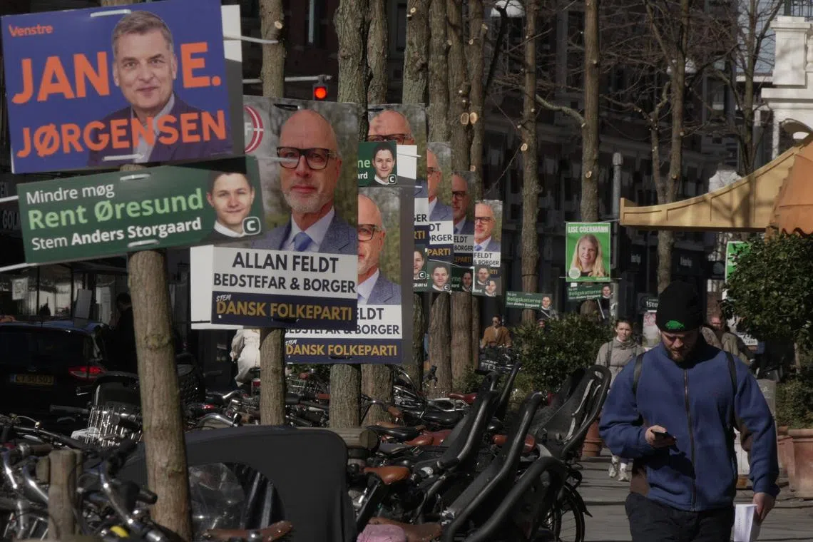 A pedestrian walks past posters for candidates in the upcoming Danish elections, in Copenhagen, Denmark, March 18, 2026. REUTERS/Tom Little