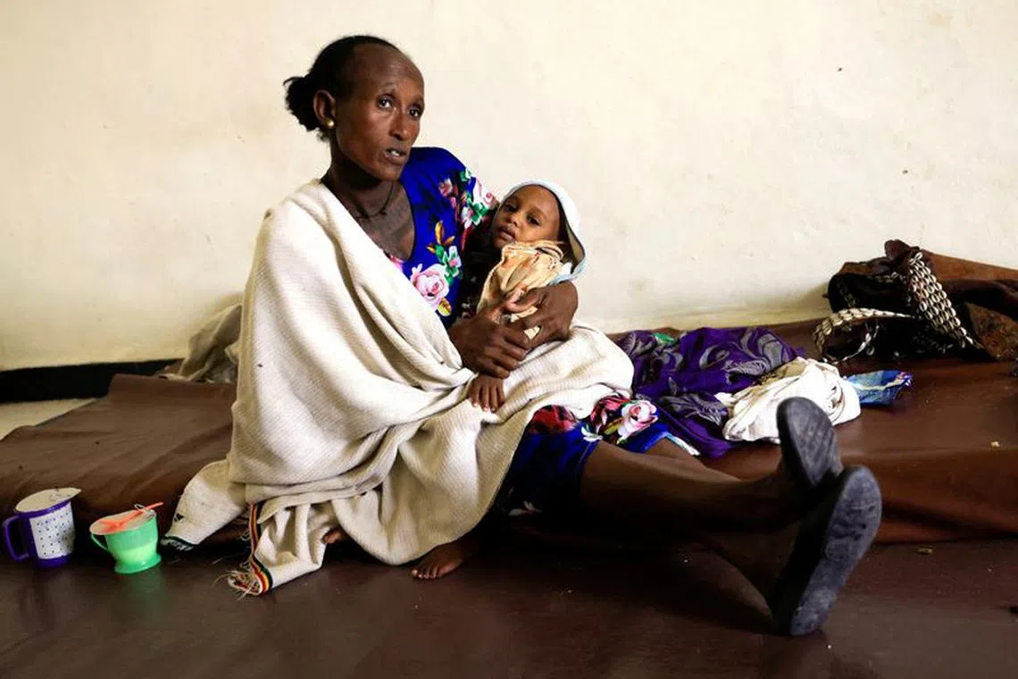 FILE PHOTO: Maeru Adugna, 45 carries her son, Kibrom Woldesillasie, 2, severely malnourished due to the food aid suspension from the United Nations World Food Program (WFP) and the U.S. Agency for International Development (USAID) at the Samre Hospital in Samre, Tigray Region, Ethiopia, June 23, 2023. REUTERS/Tiksa Negeri/File Photo